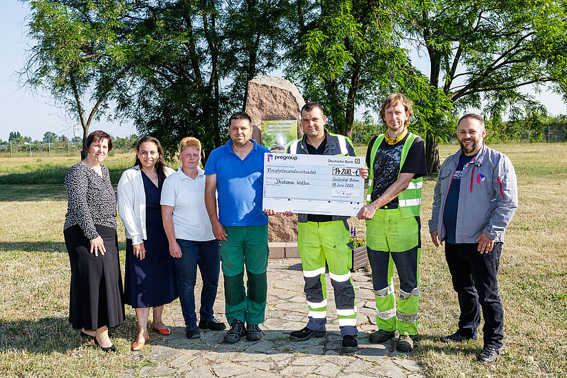 Donation handover ceremony: Phillipos Vrizas (right), Sandersdorf-Brehna site manager, and Kay Schäfer (3rd from right), PM3 dispatch manager, handed over the cheque to (left to right) Patricia Metz and Ulrike Petermann, both directors of Bitterfeld-Wolfen-Gräfenhainichen Social Welfare Association, Katrin Suchantke, group leader of the workshops for disabled people (WfbM), Holger Grusser, WfbM employee, and Marko Pilz (2nd from right), WfbM employee. Source: Jens Schlüter 